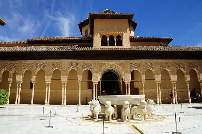 The Court of the Lions with its fountain and arcades under a blue sky