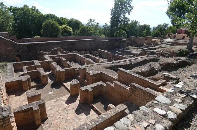 Stone foundations of the medina ruins inside the Alhambra among trees